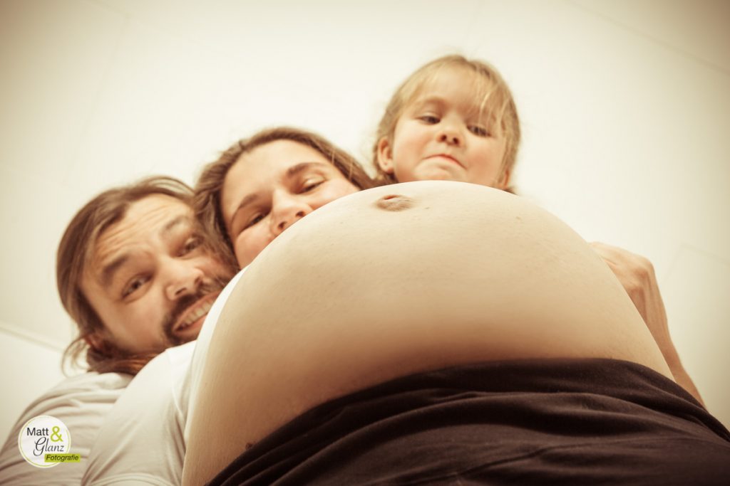 Schwangerenbauch von unten verdeckt teilweise Mutter, Vater und Kind